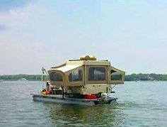 a small boat floating on top of a body of water with a camper attached to it