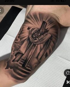 a man's arm with a tattoo on it that has a cross in the middle