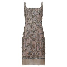 Late 1990s to 2000s Lindka Cierach couture beaded dress which takes some of its inspiration from the Art Deco and flapper style dresses of the early 1920s, with a distinctly modern flair. It has a lovely weight to it, reflective of both its quality and the two layers of silk satin underlay, which make it extra comfortable for the wearer. The exterior is made up of a beautiful mink/taupe shade of silk chiffon with beaded overlay, in tones of silver, champagne and gold. The beading arrangements feature geometric lines of sequins, floral and star shapes, as well as eight spoke wheel designs sewn with tiny, almost iridescent beads. The dress is cut in a classic shift shape, with a slightly dropped hem, and fastens down the centre back with a neatly concealed zip, topped off with a hook and eye Art Deco Outfit Modern, Art Deco Outfit, Flapper Style Dresses, Duchess Of York, South Kensington, Flapper Style, Elegantes Outfit, Geometric Lines, Style Dresses