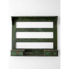 an old green wooden shelf with two drawers