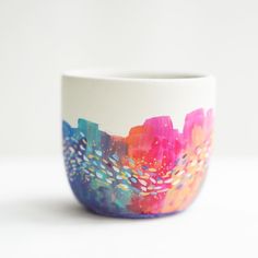 a colorful cup sitting on top of a white table