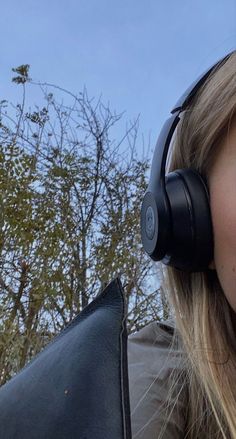 a woman with headphones on looking at the camera