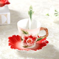 a cup with a flower painted on it and a tissue box in the back ground