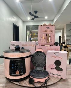 the pink crock pot is sitting on top of the table next to other items