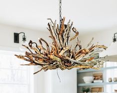 a chandelier made out of driftwood is hanging from the ceiling in a kitchen