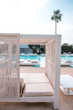 a white bed sitting next to a swimming pool