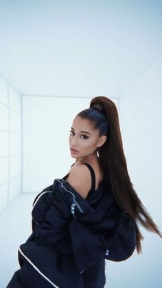 a woman with long hair standing in an empty room