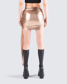 This golden drape skirt is your key to instant glam ✨ Made from lame jersey fabric, and complete with an asymmetrical hem, sash detail, ruching detail, and an elastic waistband - this skirt has a luminous allure perfect for stealing the spotlight anywhere you go 😌 Asymmetrical Stretch Skirt For Party, Asymmetrical Stretch Draped Skirt For Party, Party Draped Skirt With Ruched Detail, Party Skirt With Ruched Draped Design, Party Draped Fitted Mini Skirt, Asymmetrical Hem Stretch Mini Skirt For Party, Draped Fitted Mini Skirt For Party, Stretch Mini Skirt With Asymmetrical Hem For Party, Stretch Wrap Skirt For Party