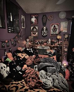 a bed with lots of halloween decorations on the wall and in front of it is a shelf full of stuffed animals