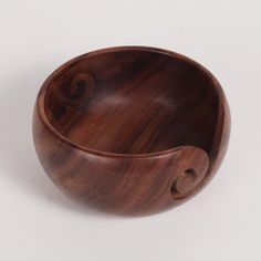 a wooden bowl with handles on a white background