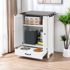 a dog food and drink station in a living room with hardwood floors, white walls and wood flooring