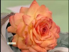 an orange rose sitting on top of a table