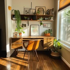 a home office with plants and pictures on the wall, along with wooden flooring