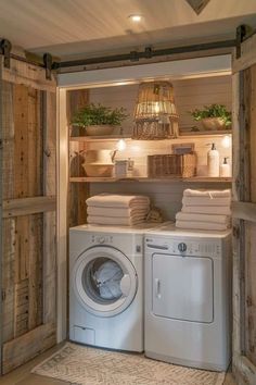 a washer and dryer in a small room with wooden paneling on the walls