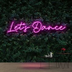 a purple neon sign that says let's dance on the side of a wall