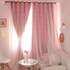 a living room with pink curtains and white furniture