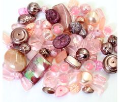 a pile of pink and brown buttons sitting on top of a white table next to each other