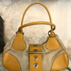 Fun Prada Tan Canvas And Leather Satchel Style Hobo. The Bag Has Two Top Handles And A Top Buckle Closure. There Is One Interior Zip Pocket. The Bag Is 14" In Length, 4.5" In Width, And 5" In Height. The Strap Drop Is 11". There Is Some Minimal Wear On The Bottom Of The Bag As Well As Near The Buckle Closure And Two Small Ink Stains On The Inside Lining. This Is A Great Everyday Bag. Ink Stains, Ink Stain, Pocket Book, Everyday Bag, Leather Satchel, Zip Pockets, Prada, Satchel, Handles