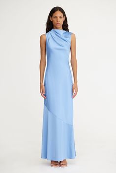 Crafted with the event season in mind, the Lana Maxi Dress in Sky is a stand out. This statement silhouette features a high neck design with a subtle cowl neck and open back feature with adjustable ties. A great option for bridesmaids, pair with a simple heel for a complete look. PRODUCT DETAILS - Maxi dress - Invisible back zip - Soft cowl neckline - Back tie detail - Unlined Composition: 62% Viscose Rayon, 38% Polyester CARE INSTRUCTIONS This fabric has been specially woven. Because of its delicate design and characteristics, please remove all jewellery when dressing. Pastel Maxi Dresses, Light Blue Gown, Sky Blue Bridesmaid Dresses, Denim Wedding, High Neck Designs, Blue Gown, Blue Bridesmaid Dresses, Viscose Rayon, Delicate Design