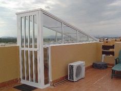 a balcony with an air conditioner and chair on the floor next to it,