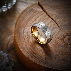 two wedding rings sitting on top of a piece of wood