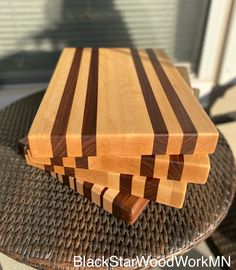 a wooden cutting board sitting on top of a metal table next to a glass door