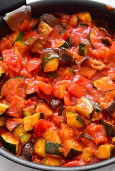 a pan filled with vegetables and sauce on top of a stove