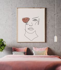 a bed with pink sheets and pillows in front of a framed drawing on the wall