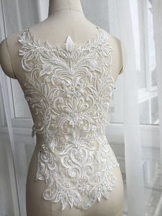 a mannequin with white lace on it in front of a window