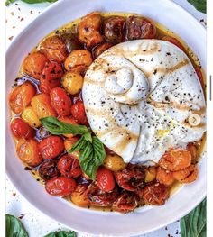 a white bowl filled with lots of different types of food on top of a table