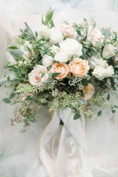 a bouquet of white and peach flowers is on display