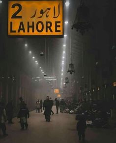 people are walking down the street in front of a sign that reads 2 lahore