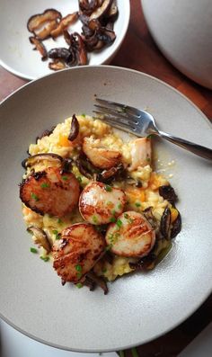 a white plate topped with shrimp and grits