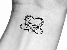 a small heart tattoo on the side of a woman's arm, with an arrow in