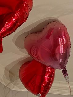 two red heart shaped balloons hanging from the ceiling