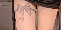 a woman's leg with a bow tattoo on it and the bottom part of her legs