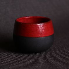 a red and black bowl sitting on top of a table