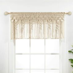 a white window with a curtain and potted plant