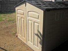 a small storage shed sitting in the middle of a yard