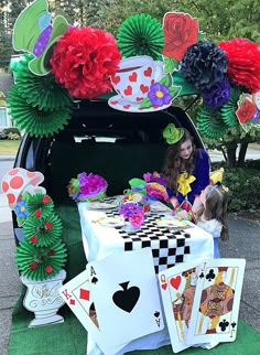 a woman sitting in the back of a car next to a table with cards and flowers on it