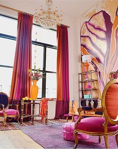 a living room filled with lots of furniture and colorful drapes on the windowsill