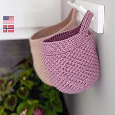 a pair of slippers hanging from a hook on a door handle next to a potted plant