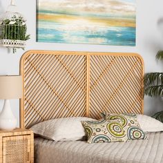 a bed with a bamboo headboard next to a lamp and painting on the wall