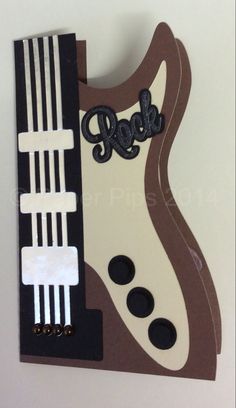 a piece of art made to look like a guitar pick up card with the word rock on it