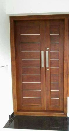 a wooden door with two sidelights on the top and bottom panels, in front of a white wall