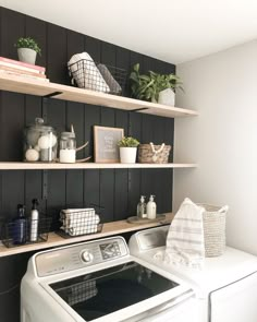 a washer and dryer in a small room with shelves above the washer