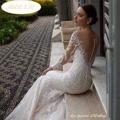 a woman in a wedding dress sitting on a ledge