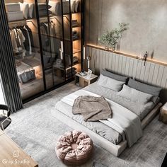 a bedroom with a large bed and lots of clothes on the shelves next to it