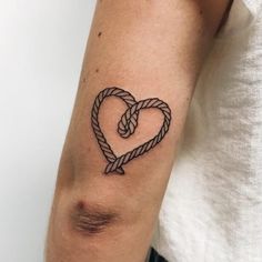 a tattoo on the arm of a man with a heart shaped knot