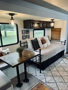 a living room filled with furniture and lots of windows in the back wall, next to a window sill